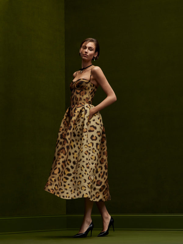 The model is wearing a jaguar-printed cocktail midi dress. 