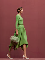 The model is wearing a green long sleeve midi dress and carrying the pale mint O ostrich feather bag. 