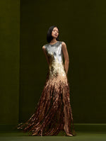 The model is wearing an ombre sequins sleeveless maxi dress that fades into fringe.