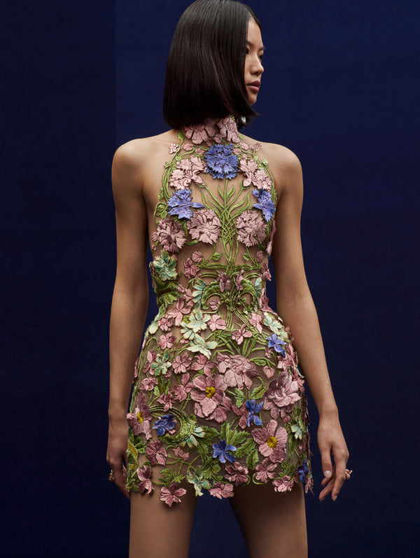 The model wears a flower embroidered halter mini dress.