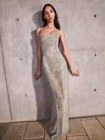 A model poses indoors in an Oscar de la Renta silver gown from the Pre-Fall 2025 collection.