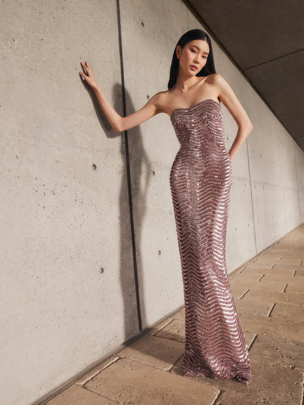 A model poses indoors in a metallic gown from Oscar de la Renta’s Pre-Fall 2025 collection. 