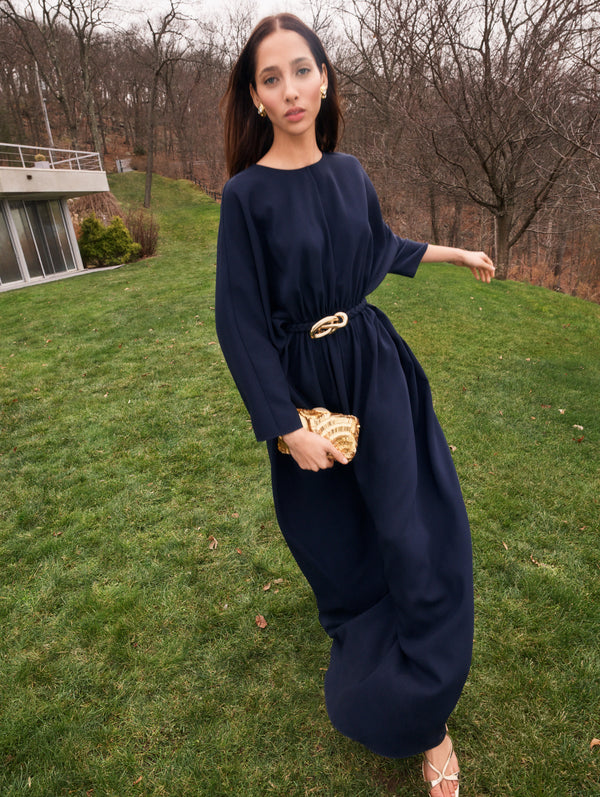 A model runs outside in a navy gown from Oscar de la Renta’s Pre-Fall 2025 collection. 