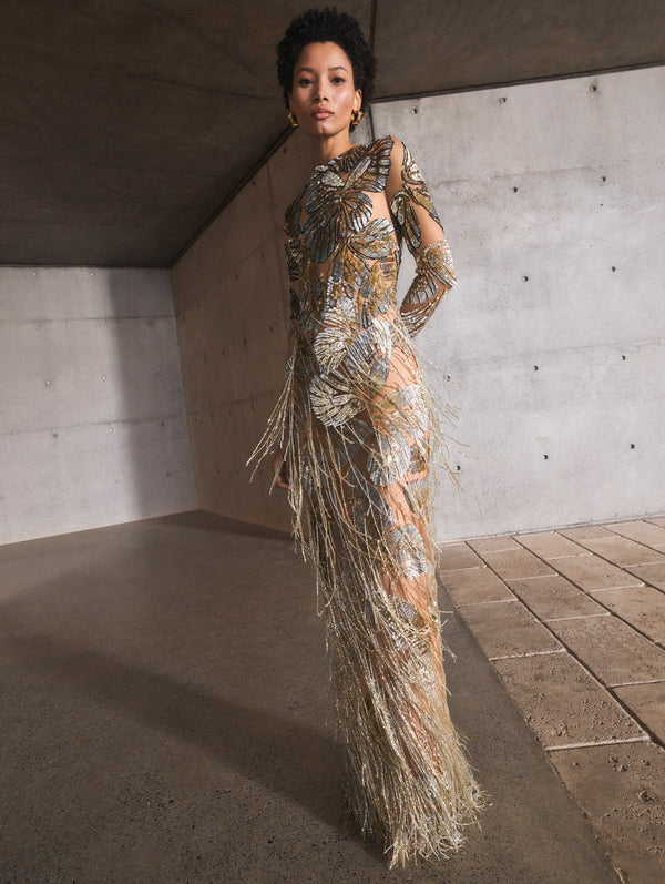 A model poses indoors in a silver embroidered gown from Oscar de la Renta’s Pre-Fall 2025 collection. 