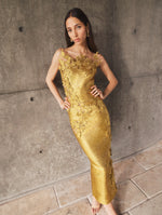 A model poses indoors in a gold strapless gown from Oscar de la Renta’s Pre-Fall 2025 collection. 