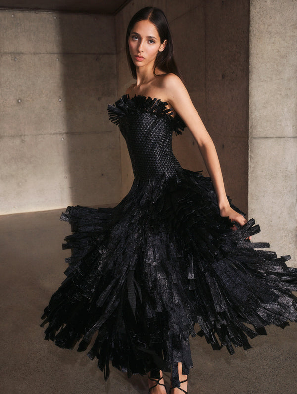 A model poses indoors in a strapless feather cocktail dress from Oscar de la Renta’s Pre-Fall 2025 collection. 