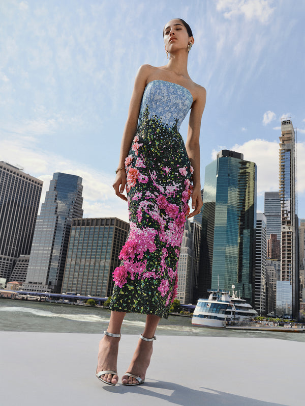 The model is wearing a strapless evening dress adorned with sequin pink English roses. 