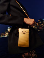 A squared-off gold shaped evening bag adorned with the Oscar ‘O’ from Oscar de la Renta's Spring 2025 collection. 